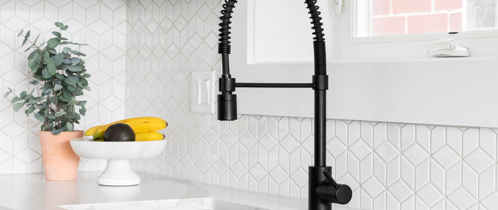 black kitchen faucet over stainless steel farmer's sink