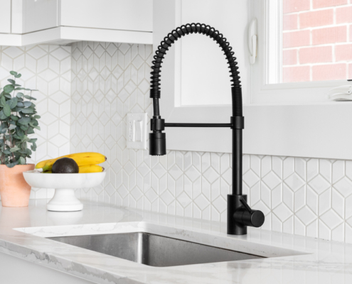 black kitchen faucet over stainless steel farmer's sink