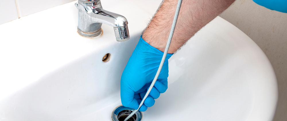 a man snaking a drain