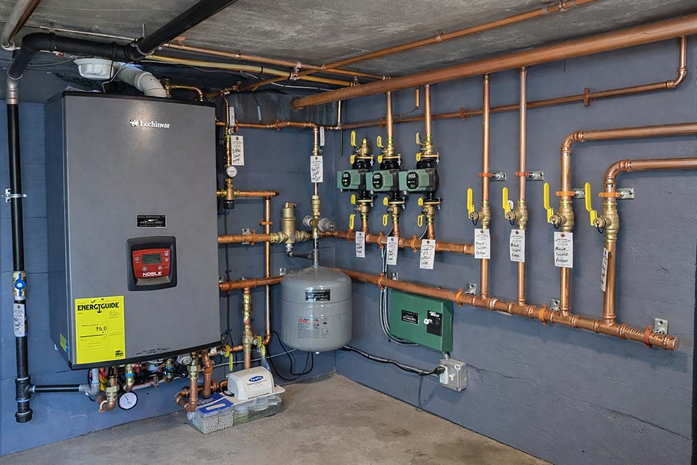 High-efficiency hot water boiler installed with copper piping and zone controls.