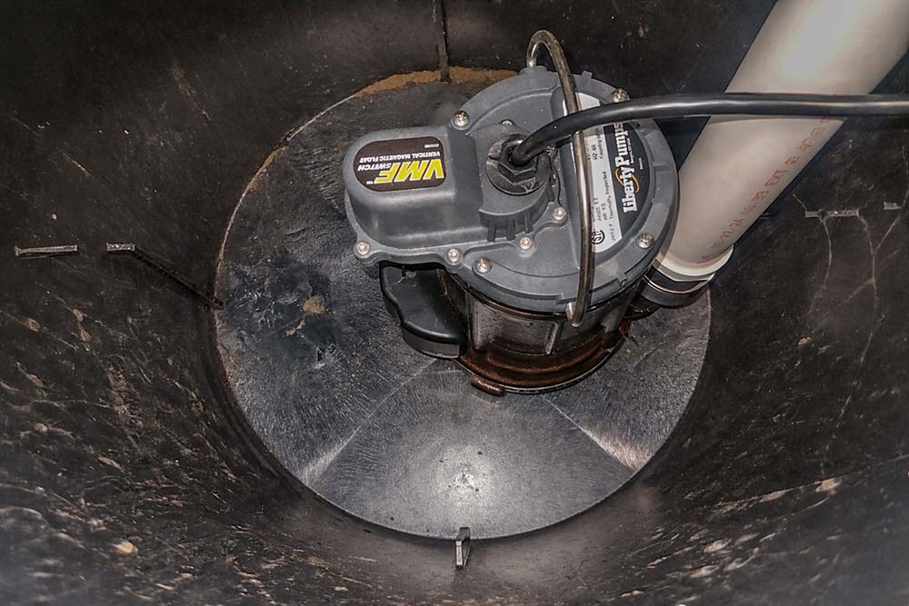 Professional sump pump installed inside a basement sump pit with PVC discharge pipe and float switch system.