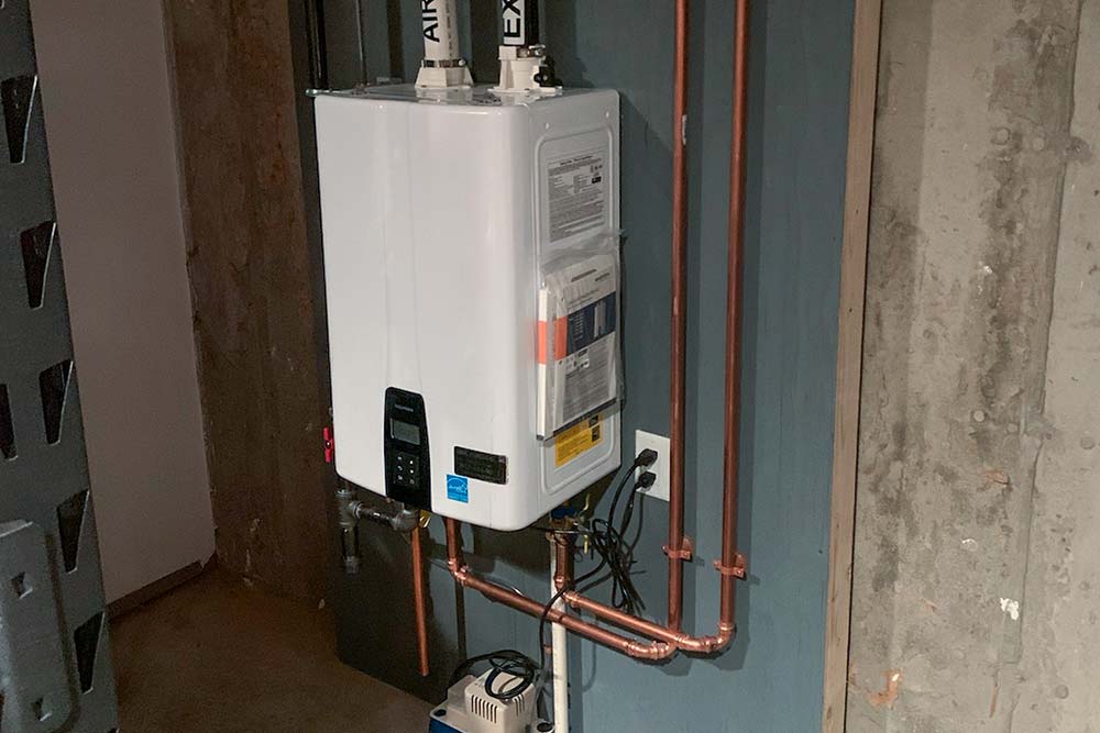Wall-mounted tankless water heater installed with copper supply lines.