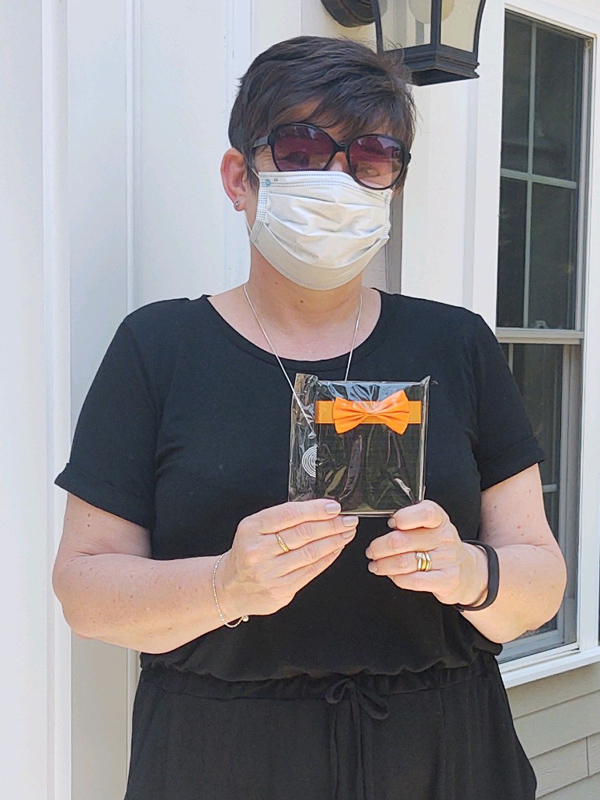 April 2021 Chase Plumbing sign contest winner holding prize outside a home.