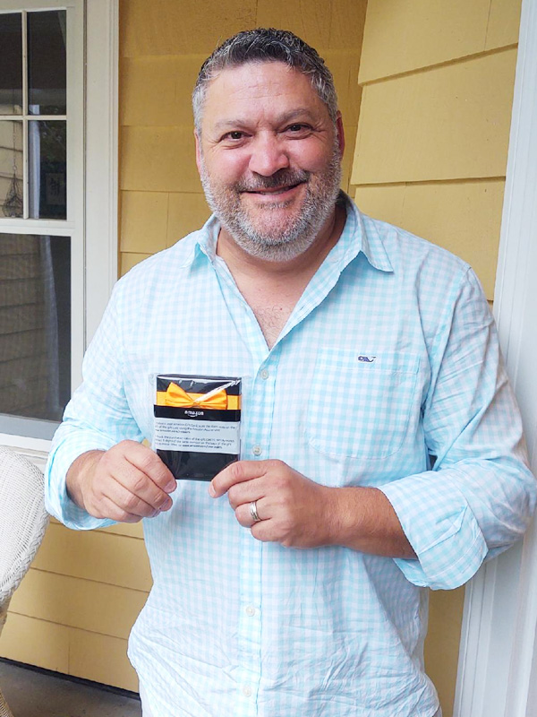 June 2021 Chase Plumbing sign contest winner holding a prize outside a home.