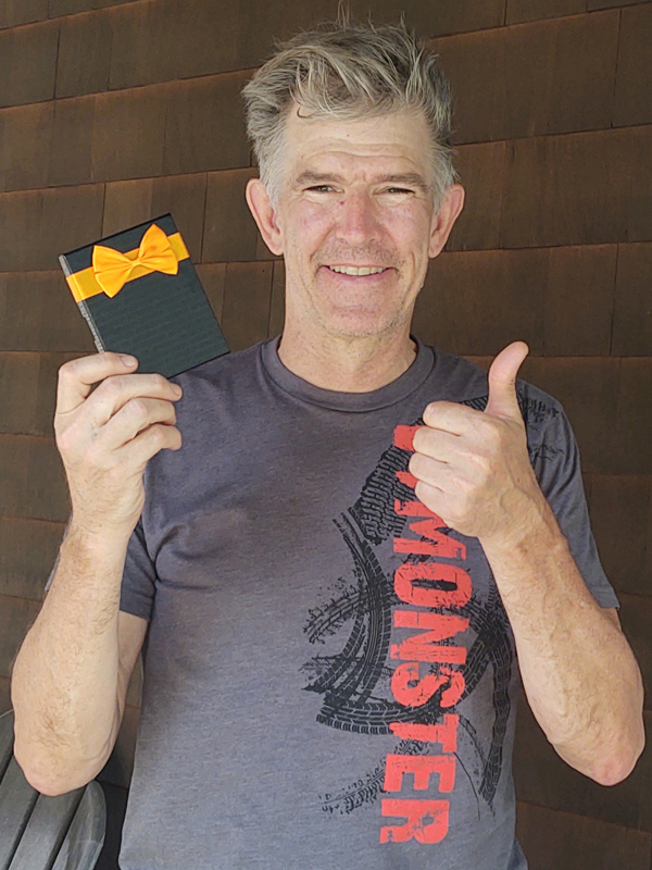 May 2021 Chase Plumbing sign contest winner holding a prize and giving a thumbs up.