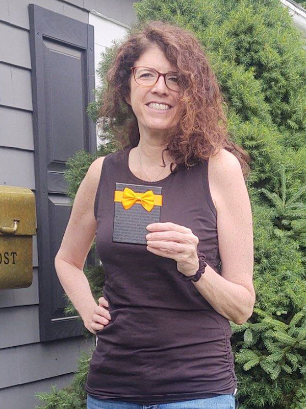May 2022 Chase Plumbing sign contest winner holding a prize outside a residence.