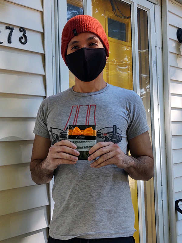 September 2020 Chase Plumbing sign contest winner holding a prize in front of a home entrance.